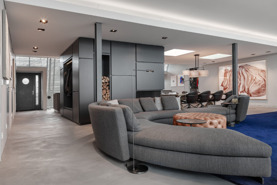 Dopo Domani, LOFT IN DER STADT living room, with a grey sofa, a blue carpet, and a leather center table, as well as a fireplace.  dopo domani 10 Stunning Dopo Domani Interiors To Inspire You 20200110 dopo domani loft B 109 scaled 1