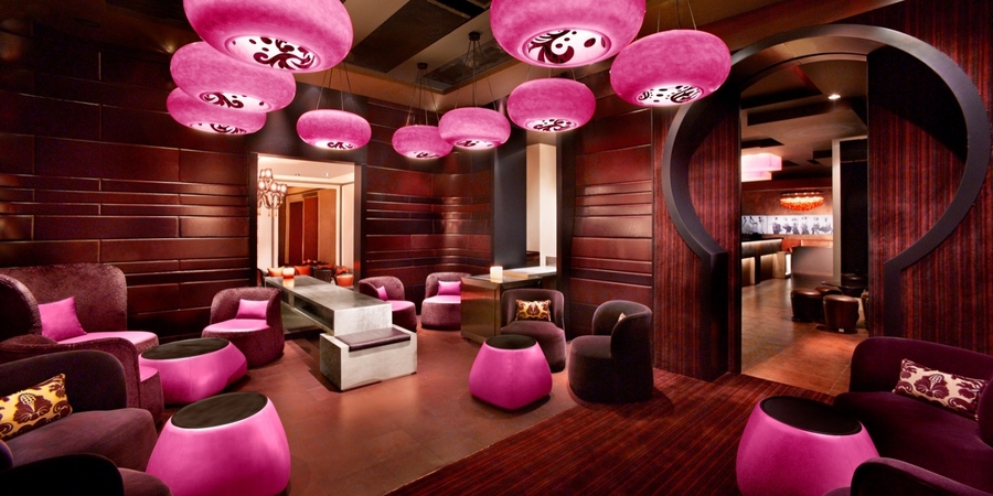 Dark living room with wood walls and pink details accompanied with custom velvet and leather upholstery.  hba HBA &#8211; The Best Interior Design Projects in Dubai HBA4