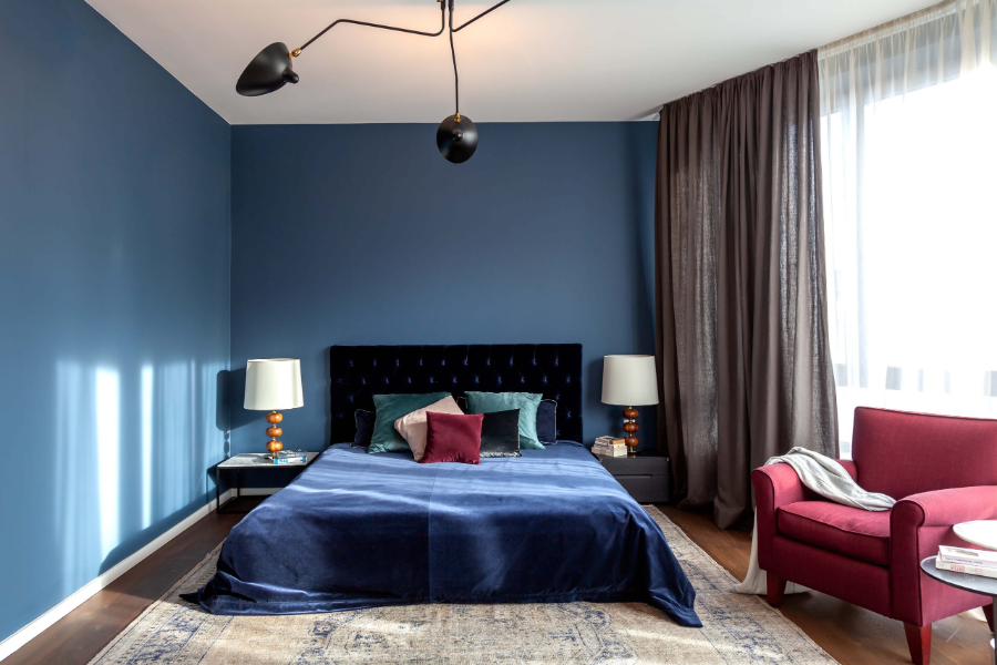 Dopo Domani, ZUHAUSE IN MITTE bedroom with a blue bed and blue wall, and a purple armchair.  dopo domani 10 Stunning Dopo Domani Interiors To Inspire You dopo domani maisonette A 15 scaled 1