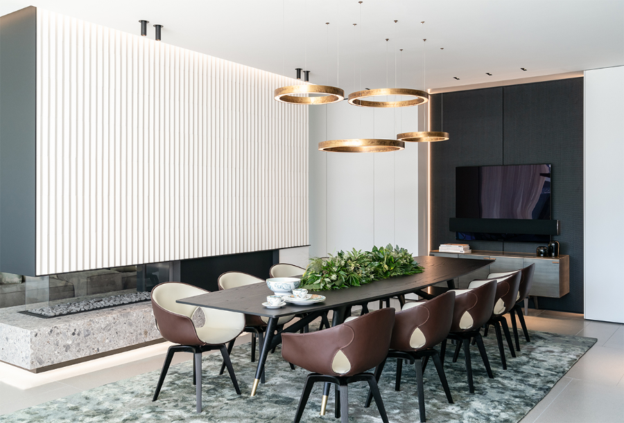 LINEA NERA modern interior design ideas, dining room area with leather dining chairs, a dining table in dark wood, some chandeliers, and a fireplace.   LineaNera  Reimann Architecture Modern Interior Design Ideas